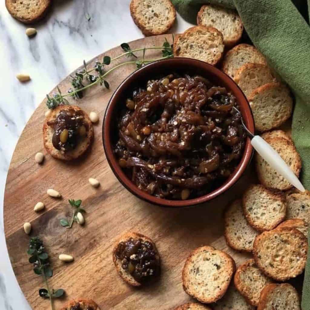 This recipe for Eggplant Caponata is a delicious, non-traditional Italian appetizer made with roasted eggplant, olive oil, honey, balsamic vinegar, pine nuts, and capers. This baked Eggplant appetizer provides a different take on the Sicilian classic -simultaneously sweet and sour, with just one bite, you’re hooked!