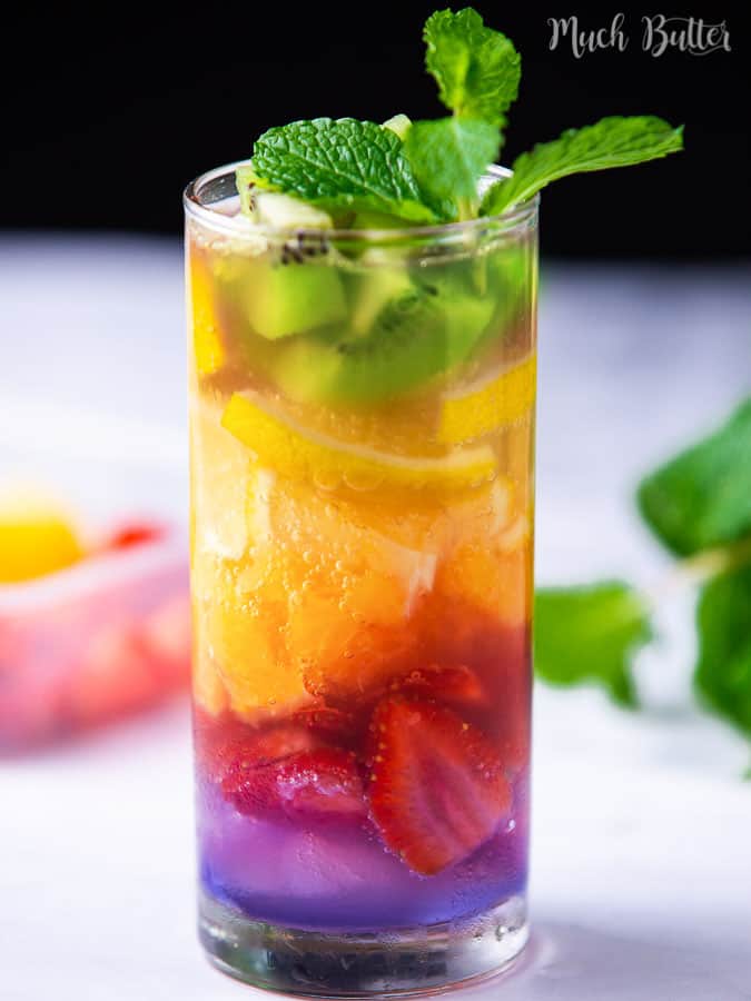 Rainbow fruit sparkling water consists of some fresh fruits and soda in a glass.