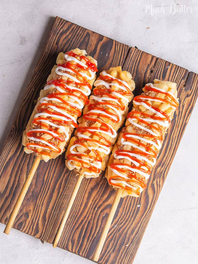 Coddling your movie time with Korean Corn Dog! It is mozzarella or sausage coated with diced french fries and panko breadcrumbs. Using the deep-fried method, this snack will be cheesy, crunchy, and tasty. 