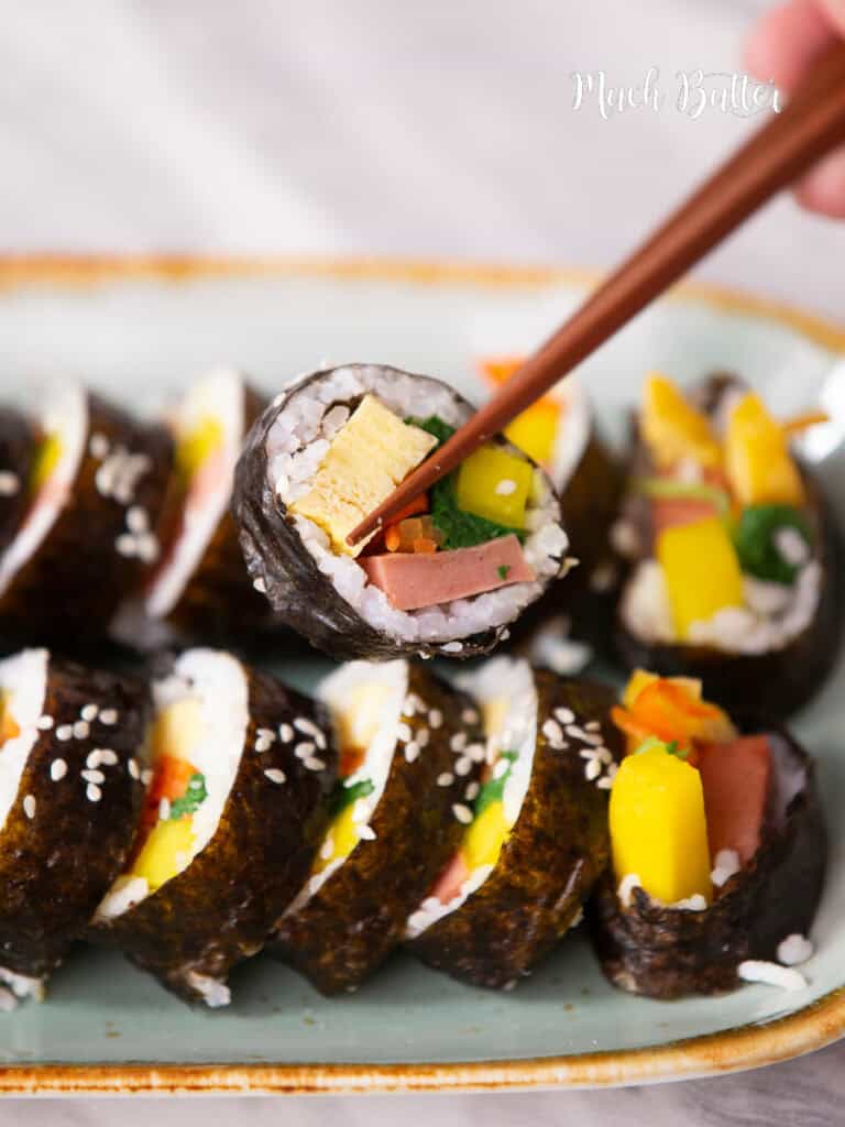 Spam Kimbap is really what you need! A delicious Korean-style sushi roll filled with warm rice, spam meat, spinach, yellow pickled radish, egg, and carrots.